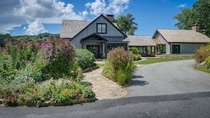A two-story house with a stone pathway leading to the entrance, surrounded by well-maintained gardens. - Modern-rustic Glenville Cabin: Golf, Hike + Unwind (Glenville)