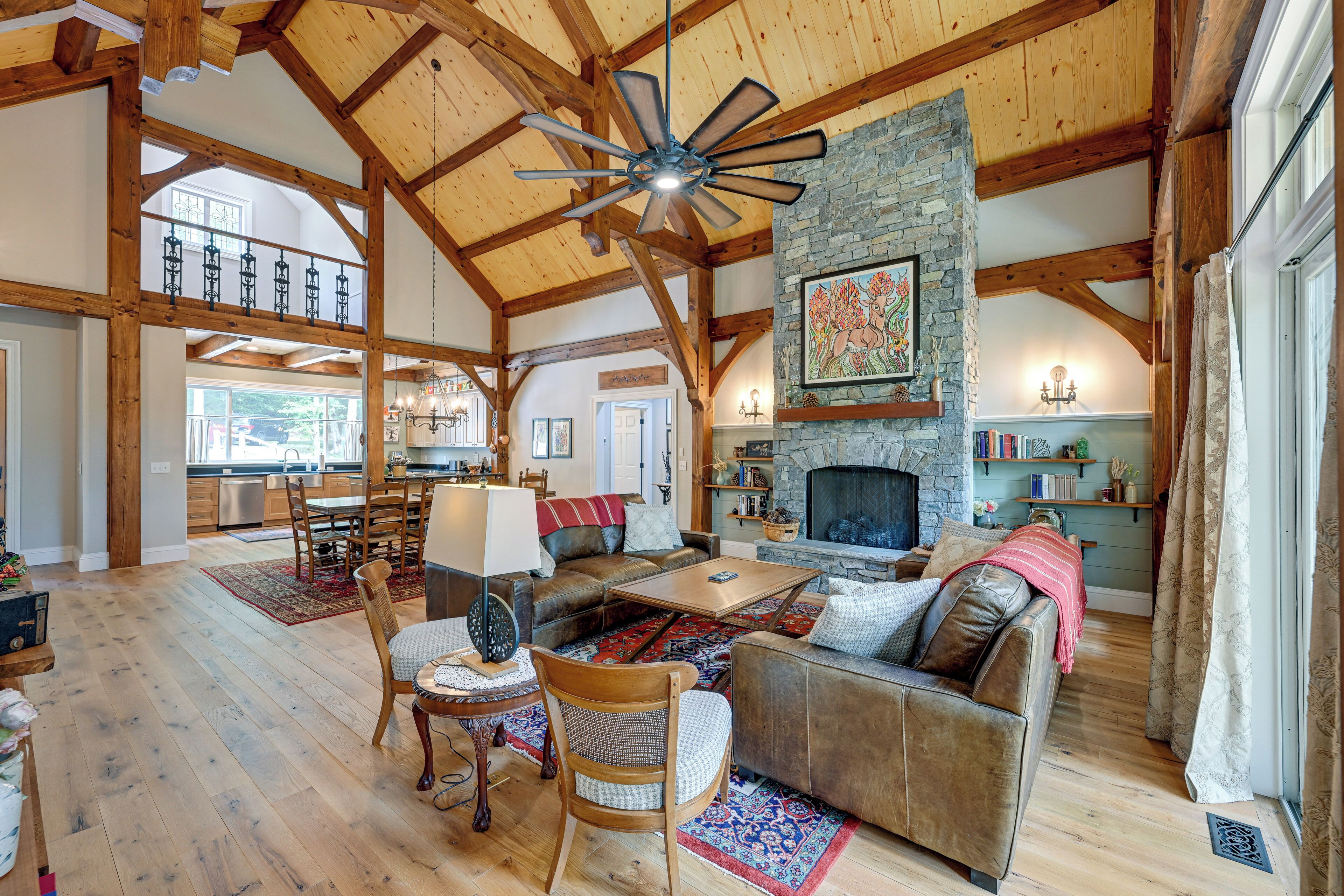 A spacious living area with a fireplace, wooden beams, and a dining area with a table and chairs.
