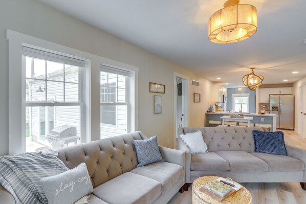 A spacious living room with two beige sofas, a coffee table, and a large window. - Port Clinton Vacation Rental w/ Boat Dock & Grill! (Port Clinton)