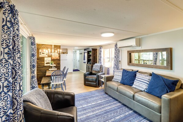 A living room with a sofa, armchairs, a dining table, and a kitchen in the background. - Edgemont Waterfront Cabin Rental w/ Beach Access! (Edgemont)
