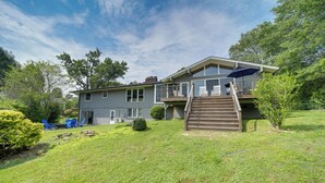A two-story house with a balcony, a staircase, and a small deck area. - Centrally Located Brevard Home w/ Deck & Fire Pit! (Brevard)