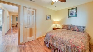 A bedroom with a bed, a ceiling fan, a nightstand, and a lamp. - Deck & Water View: Cozy Kentucky Lake Getaway (New Concord)