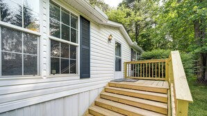 A wooden staircase leading to a porch with a railing, adjacent to a white building with large windows and a door. - North Carolina Home Near Mountain Biking & Fishing (Pisgah Forest)