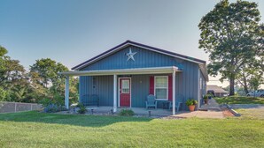 A single-story building with a porch, a red door, and a star on the roof. - Kentucky Retreat Near Williamstown Lake! (Williamstown)