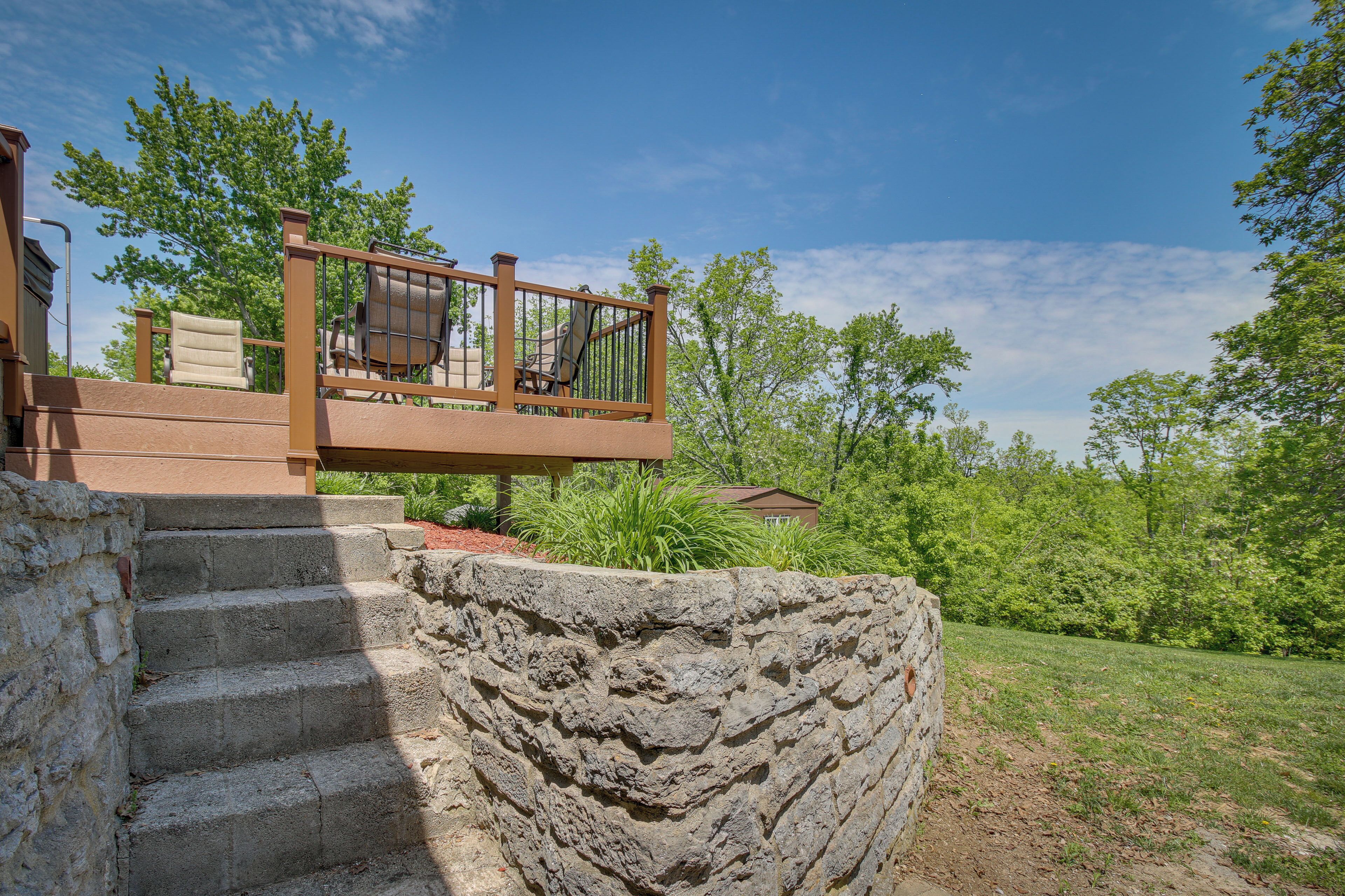 A stone staircase leading to a wooden deck with outdoor furniture.