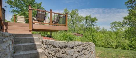 A stone staircase leading to a wooden deck with outdoor furniture.