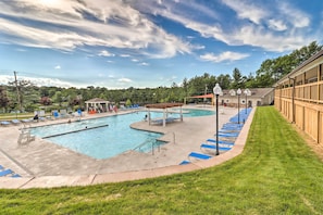 A swimming pool with lounge chairs and a gazebo.