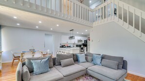 A spacious living area with a gray sectional sofa, a colorful rug, and a staircase leading to an upper level. - Community Perks: Family Poconos Home w/ Deck! (Tobyhanna)