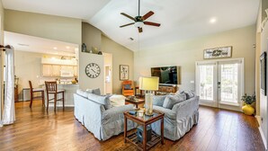 A spacious living room with a sofa set, a coffee table, and a television. - Private Outdoor Pool in Naples Vacation Rental! (Naples)