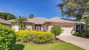 A two-story house with a covered driveway and a well-maintained lawn. - Private Outdoor Pool in Naples Vacation Rental! (Naples)