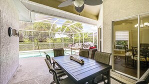 A covered patio with a pool, outdoor furniture, and a ceiling fan. - Private Outdoor Pool in Naples Vacation Rental! (Naples)