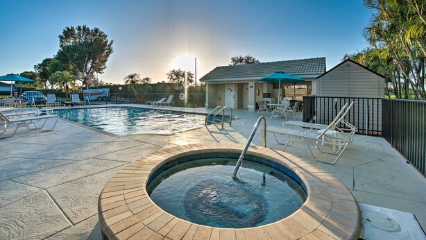 A swimming pool area with lounge chairs, a hot tub, and a building with a tiled roof. - Private Outdoor Pool in Naples Vacation Rental! (Naples)