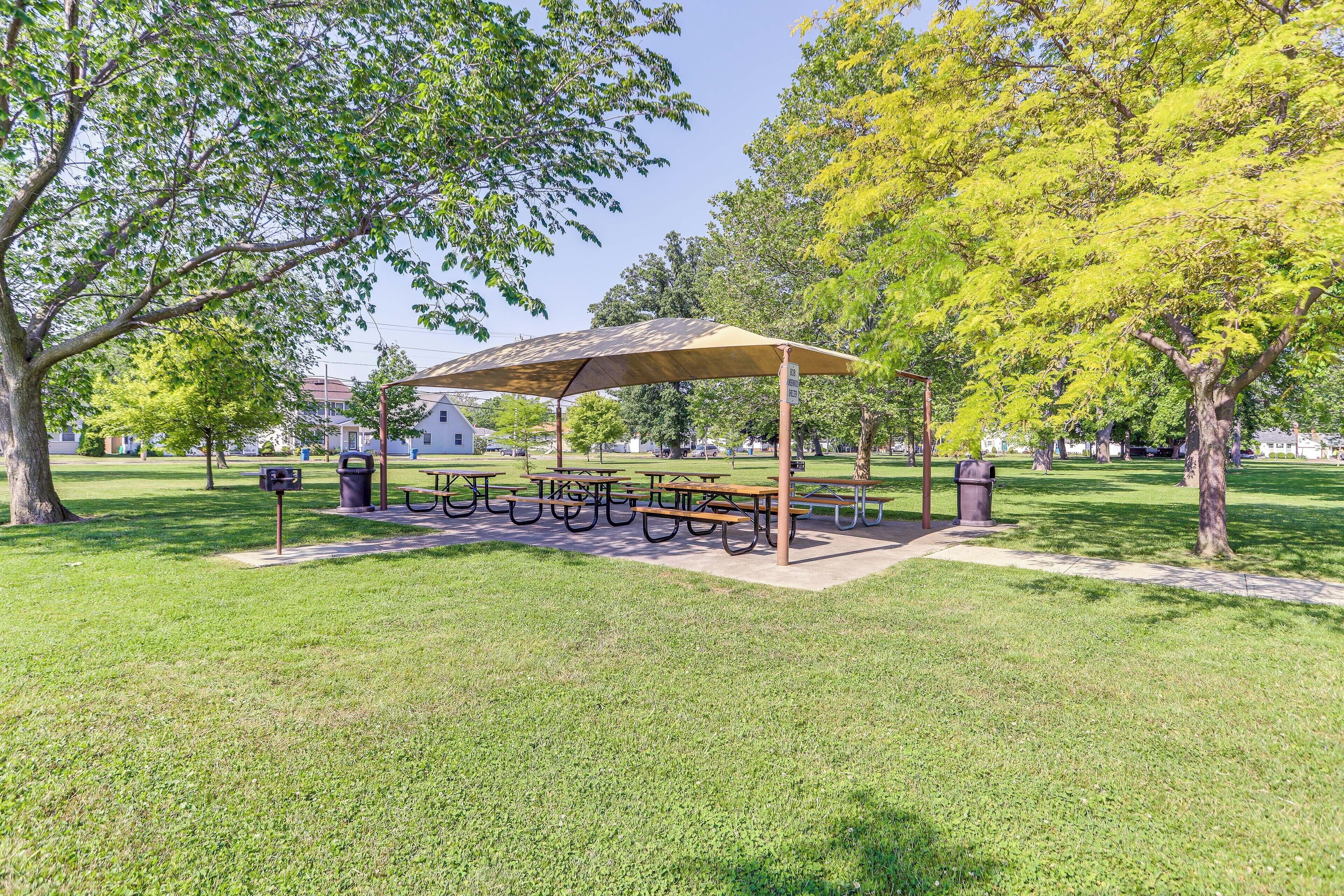 A park with picnic tables and a covered seating area.