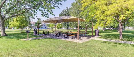 A park with picnic tables and a covered seating area.