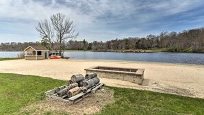 A lakeside property with a wooden deck, a small shed, and a concrete fire pit area. - Hot Tub + Lake Access: Spacious Tobyhanna Home (Tobyhanna)