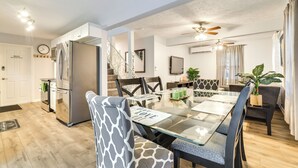 A modern kitchen with a refrigerator, dining table, chairs, and a staircase leading to another level. - 5 Mi to Tobyhanna State Park: Home w/ Game Room! (Tobyhanna)