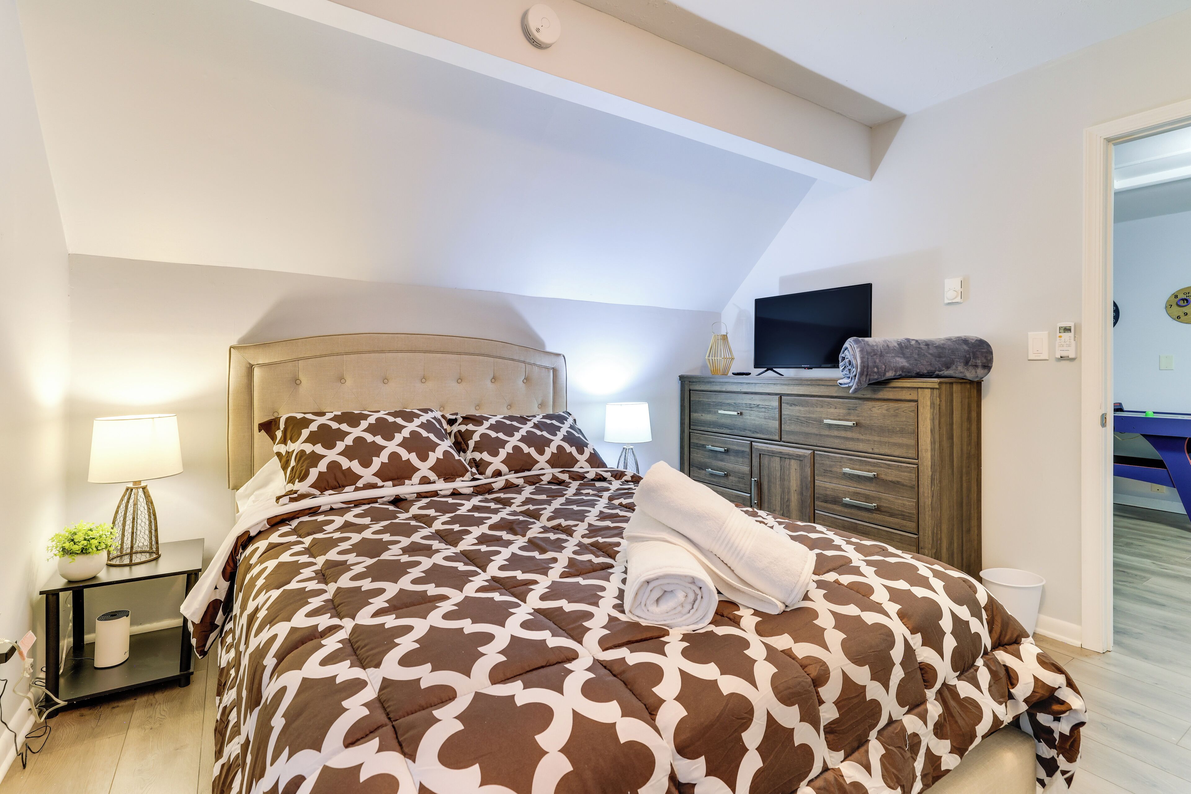 A bedroom with a bed, bedside tables, a TV, and a wardrobe.