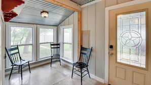 A room with three wooden chairs, a door with a stained glass window, and a ceiling fan. - Lake Brownwood Home w/ Private Boat Dock! (Brownwood)