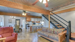 A spacious living area with a wooden ceiling, a sofa, a red armchair, and a staircase. - Lake Brownwood Home w/ Private Boat Dock! (Brownwood)