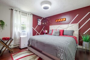 Une chambre à coucher moderne, avec un lit, une table de chevet, un radiateur et une fenêtre avec des rideaux.