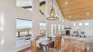 A spacious dining area with a wooden table, chairs, and a chandelier.