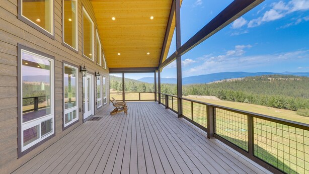A wooden deck with a view of a mountainous landscape.
