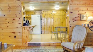 A wooden cabin interior with a kitchen, dining area, and a rocking chair. - Waterfront Pequot Lakes Cabin: Fire Pit + Views! (Pequot Lakes)