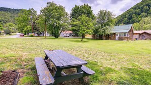 Una mesa de picnic en un campo cubierto de césped, con casas y árboles al fondo.