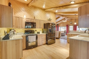 Una cocina amplia con gabinetes de madera, un refrigerador de acero inoxidable y una isla grande con un lavamanos.