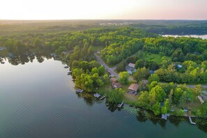 An aerial view of a lakeside property with several houses, docks, and boats.