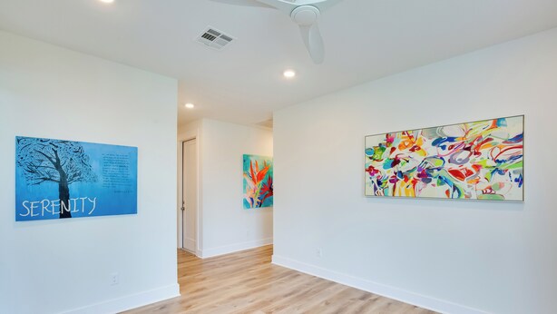 A hallway with wooden flooring, white walls, and three artworks. - On Cedar Creek Reservoir: Malakoff Home w/ Pool! (Malakoff)