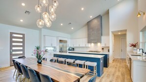 A spacious kitchen with a central island, modern appliances, and a dining area with a wooden table and chairs. - On Cedar Creek Reservoir: Malakoff Home w/ Pool! (Malakoff)