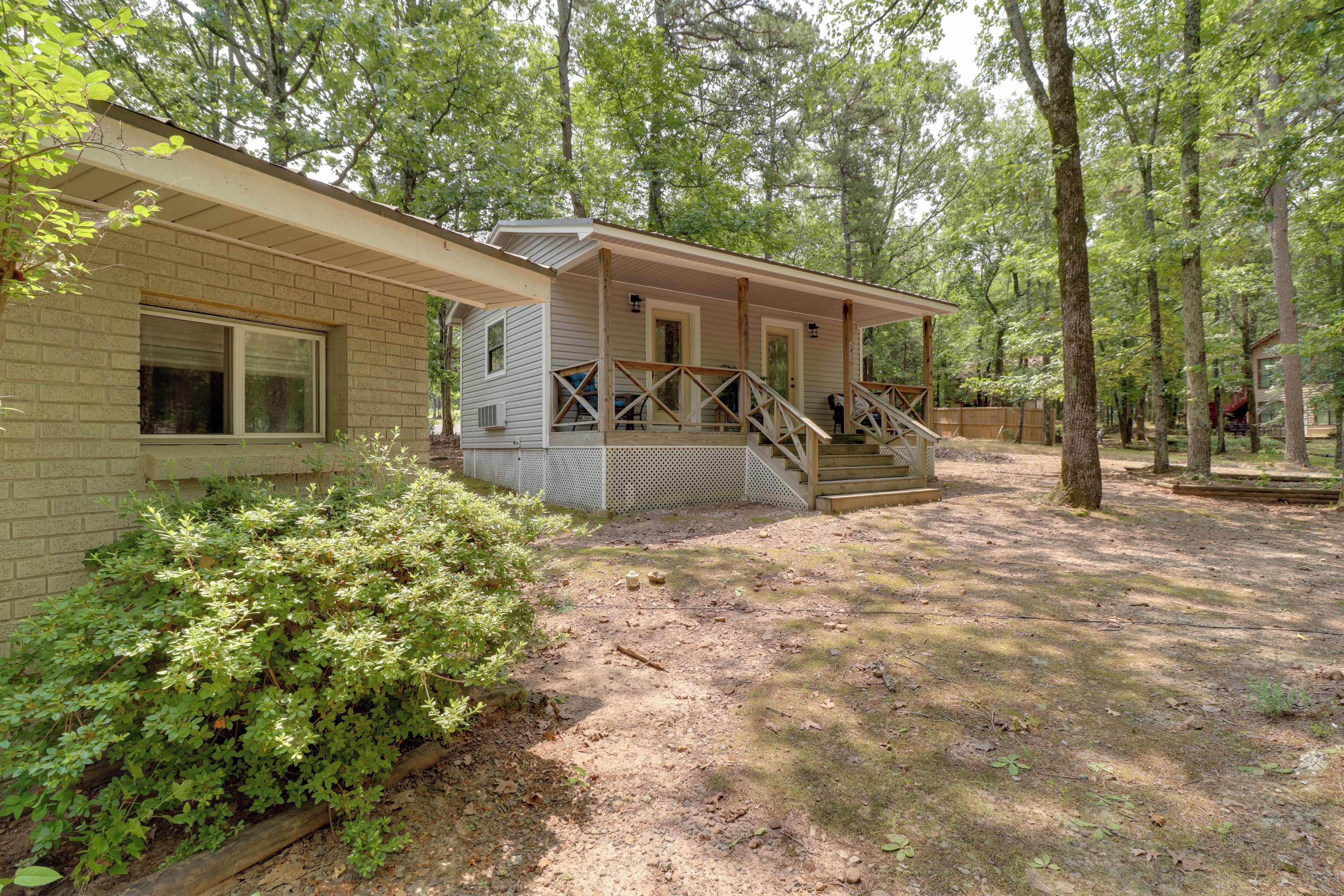A two-story cabin with a porch and a staircase leading to the upper level.