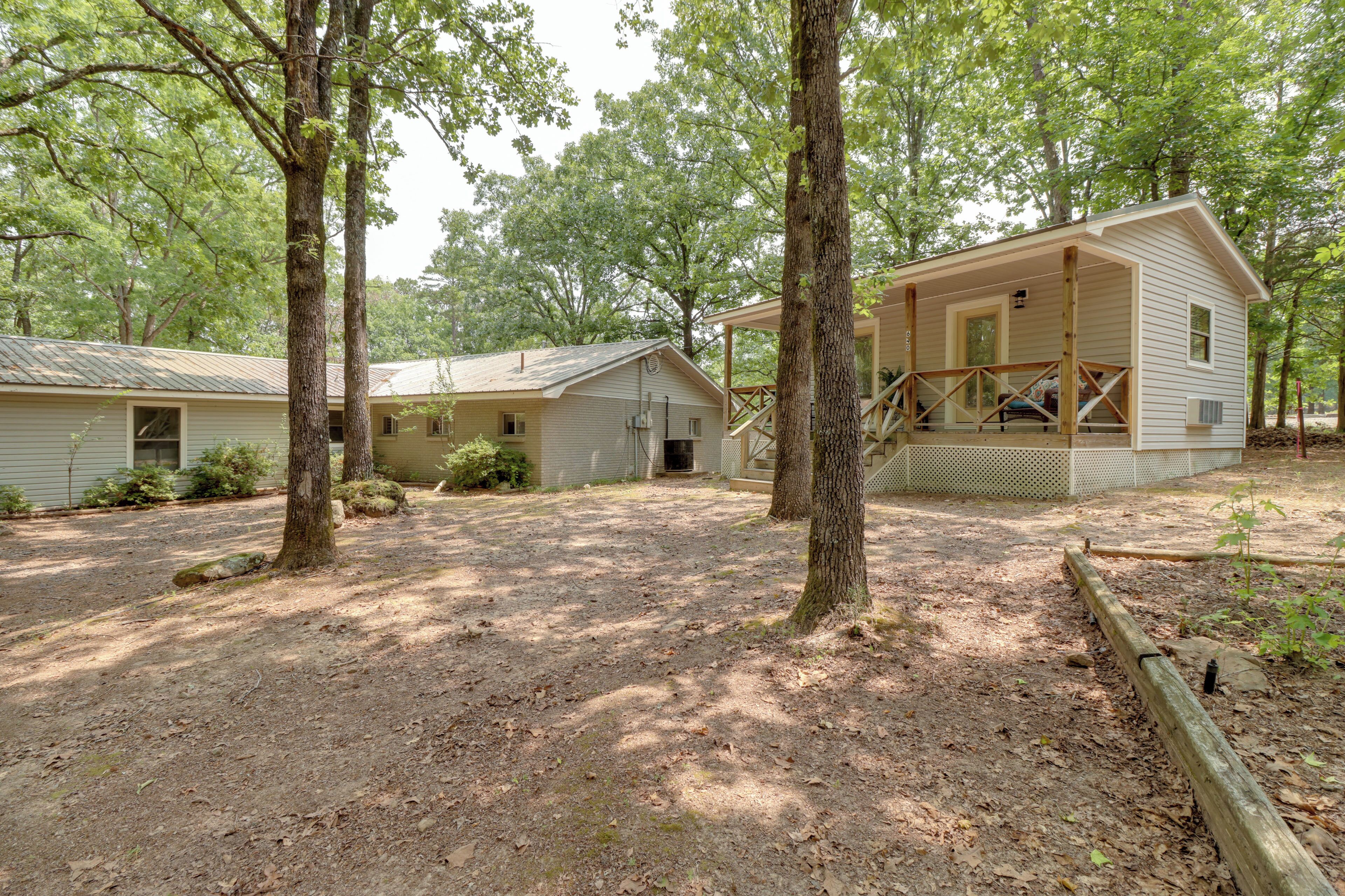 A cabin with a porch, surrounded by trees.