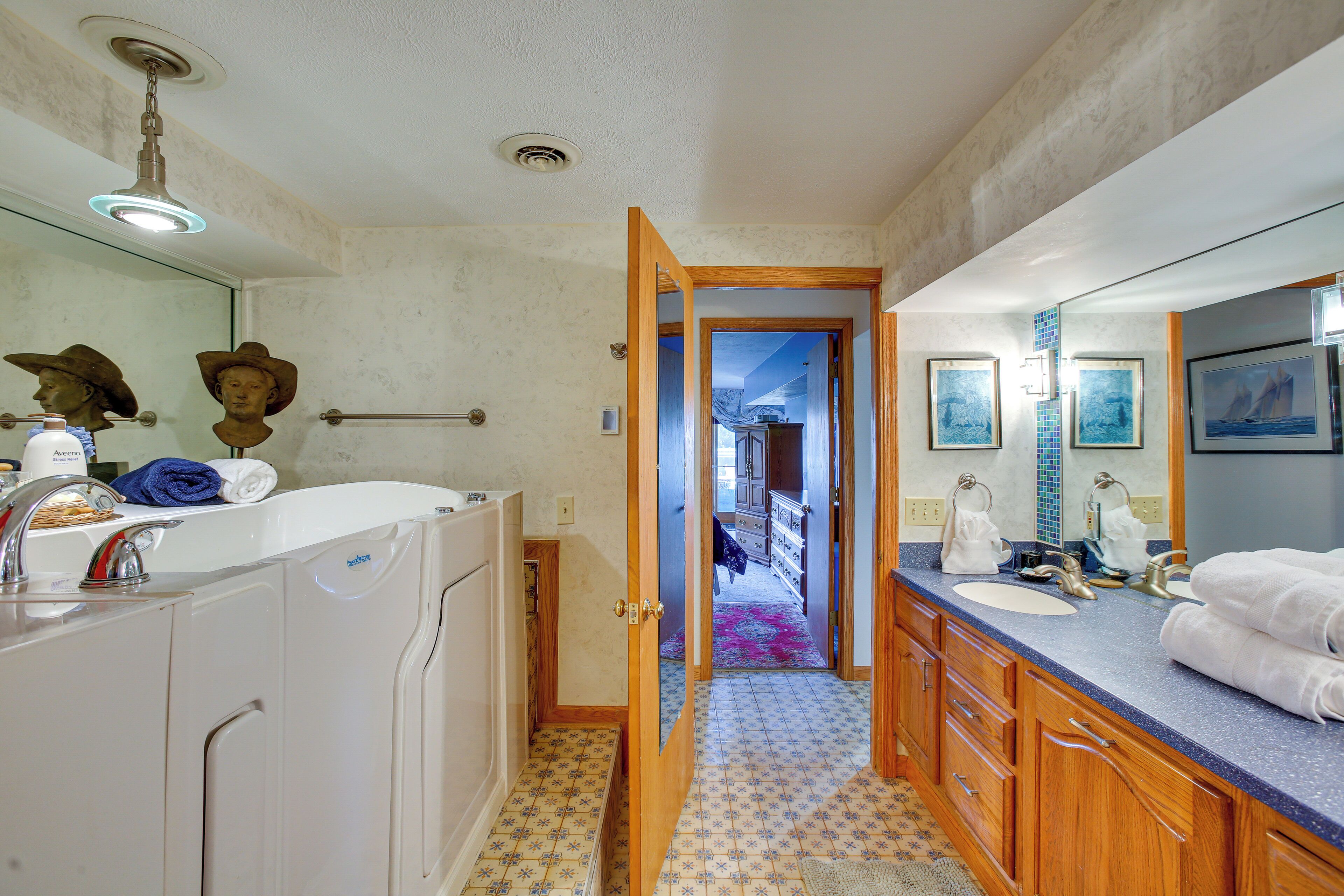 Une salle de bain avec un grand miroir, deux lavabos et une douche.