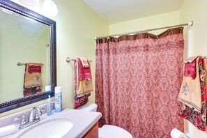 Une salle de bain avec un lavabo, un miroir et des toilettes.