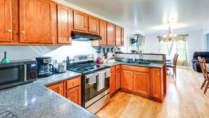 A kitchen with wooden cabinets, a microwave, a stove, and a sink. - Peaceful Getaway in Blonts Creek Near Washington (Blounts Creek)