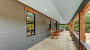 A covered porch with wooden flooring, built-in rocking chairs, and a view of a green landscape. - Sip, Fish & Relax Fireside: Serene Schulenburg Gem (Schulenburg)
