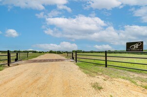 A dirt road leading to a gated area with a sign reading "THE HIDEAWAY".