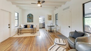 A spacious living room with hardwood flooring, a ceiling fan, a sofa, a coffee table, and a dining area with chairs. - Sip, Fish & Relax Fireside: Serene Schulenburg Gem (Schulenburg)
