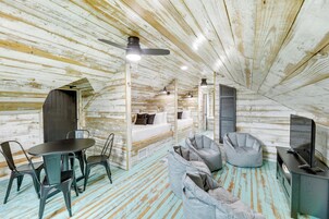 Acogedor dormitorio en ático con cama, zona de estar y televisión.