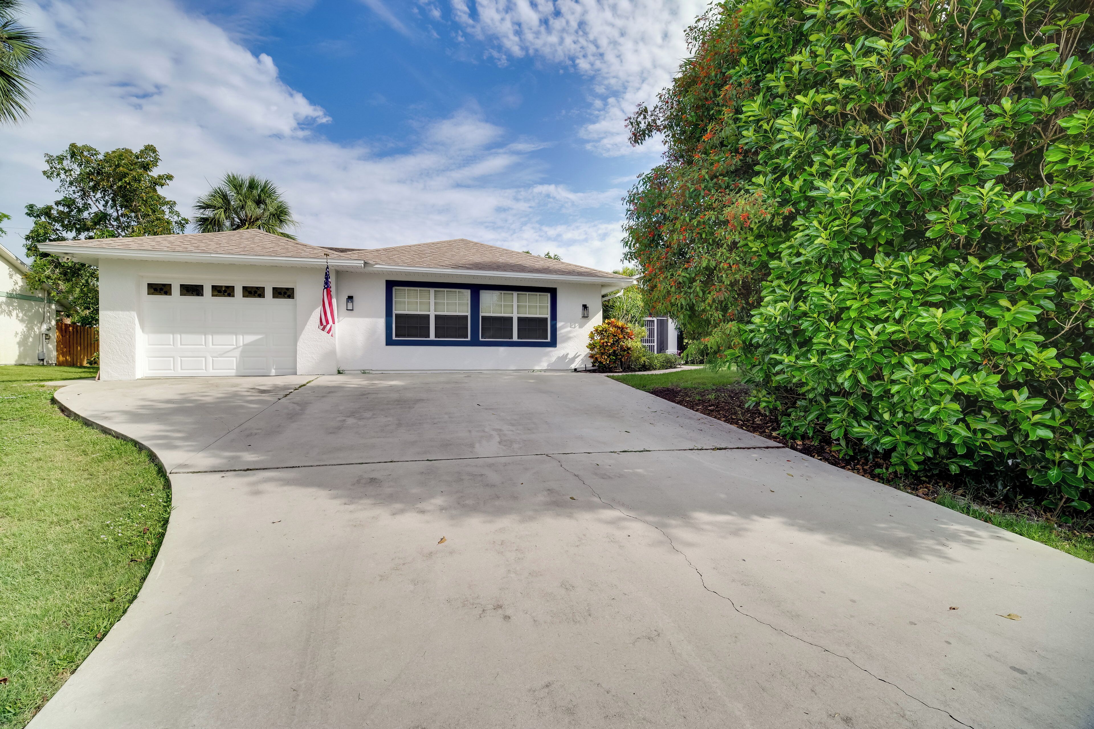A single-story house with a garage, a driveway, and a well-maintained lawn.