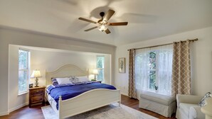 A bedroom with a bed, bedside tables, a ceiling fan, a window with curtains, a sofa, and a patterned rug. - 'casa Blanco' Escape w/ Fire Pit in Sebastian! (Sebastian)