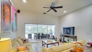 A spacious living room with a sofa, coffee table, and TV. - 'casa Blanco' Escape w/ Fire Pit in Sebastian! (Sebastian)