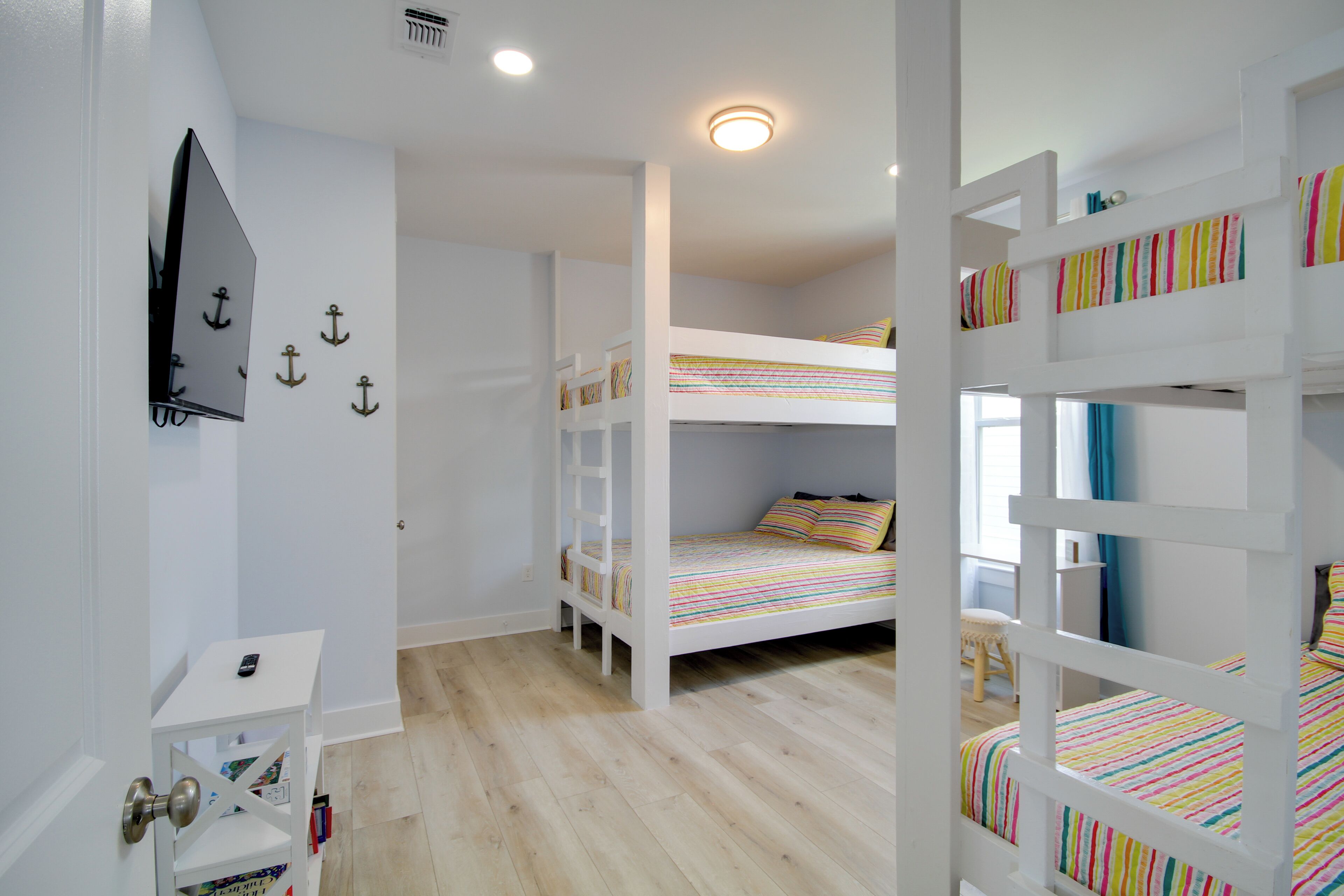 Una habitación con literas, un escritorio pequeño y una puerta con picaporte.