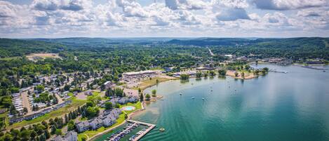 An aerial view of a lakeside community with residential buildings, a marina, and a park.