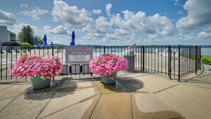 A lifeguard station with a sign, a large flower pot, and a view of the beach. - Luxury Lakefront Boyne City Townhome w/ Views! (Boyne City)