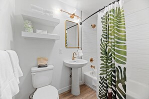 Eenvoudige kamer | Badkamer | Een bad/douchecombinatie, designer toiletartikelen, een haardroger