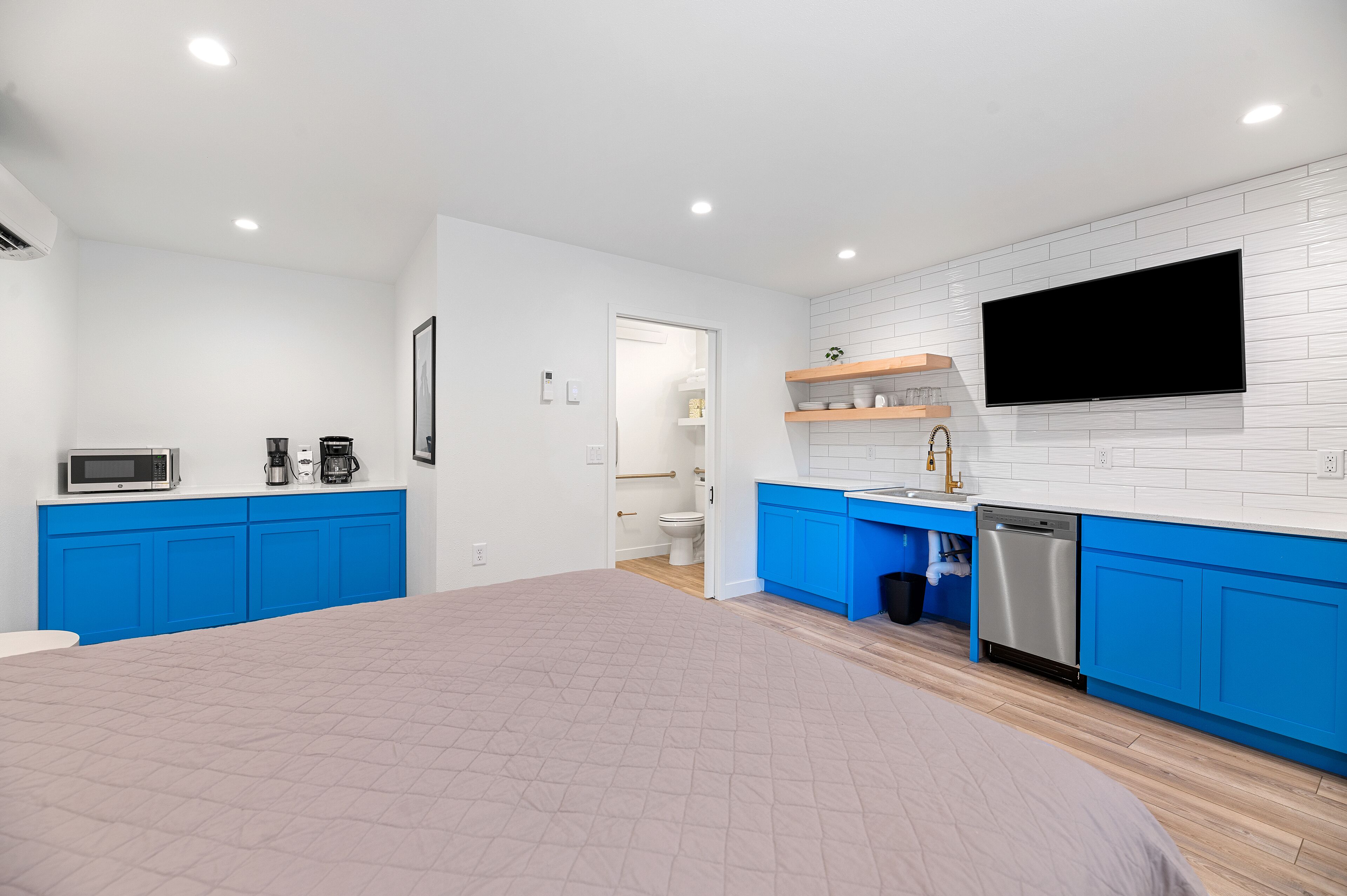 Una cocina moderna con armarios azules, un microondas y un lavavajillas.