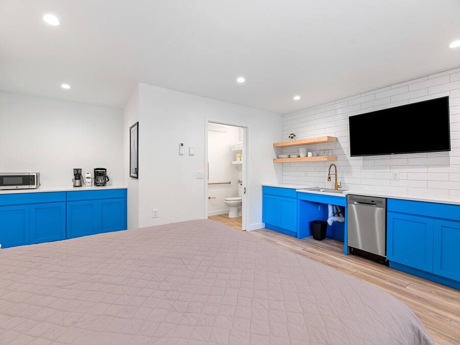 Una cocina moderna con armarios azules, un microondas y un lavavajillas.